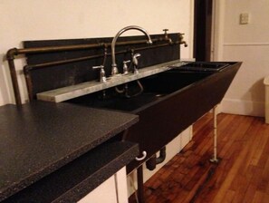 Compact kitchen with sink and stainless steel faucet.