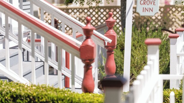 A white fence with a sign reading 'Pacific Grove Inn.' - Blocks from Ocean - KING BEDROOM SUITE (PACIFIC GROVE)