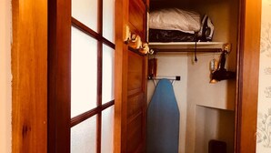 Perinteinen japanilaistyylinen huone, jossa on liukuovi, hylly, jossa on silityslauta, ja seinälle ripustettava silitysrauta.