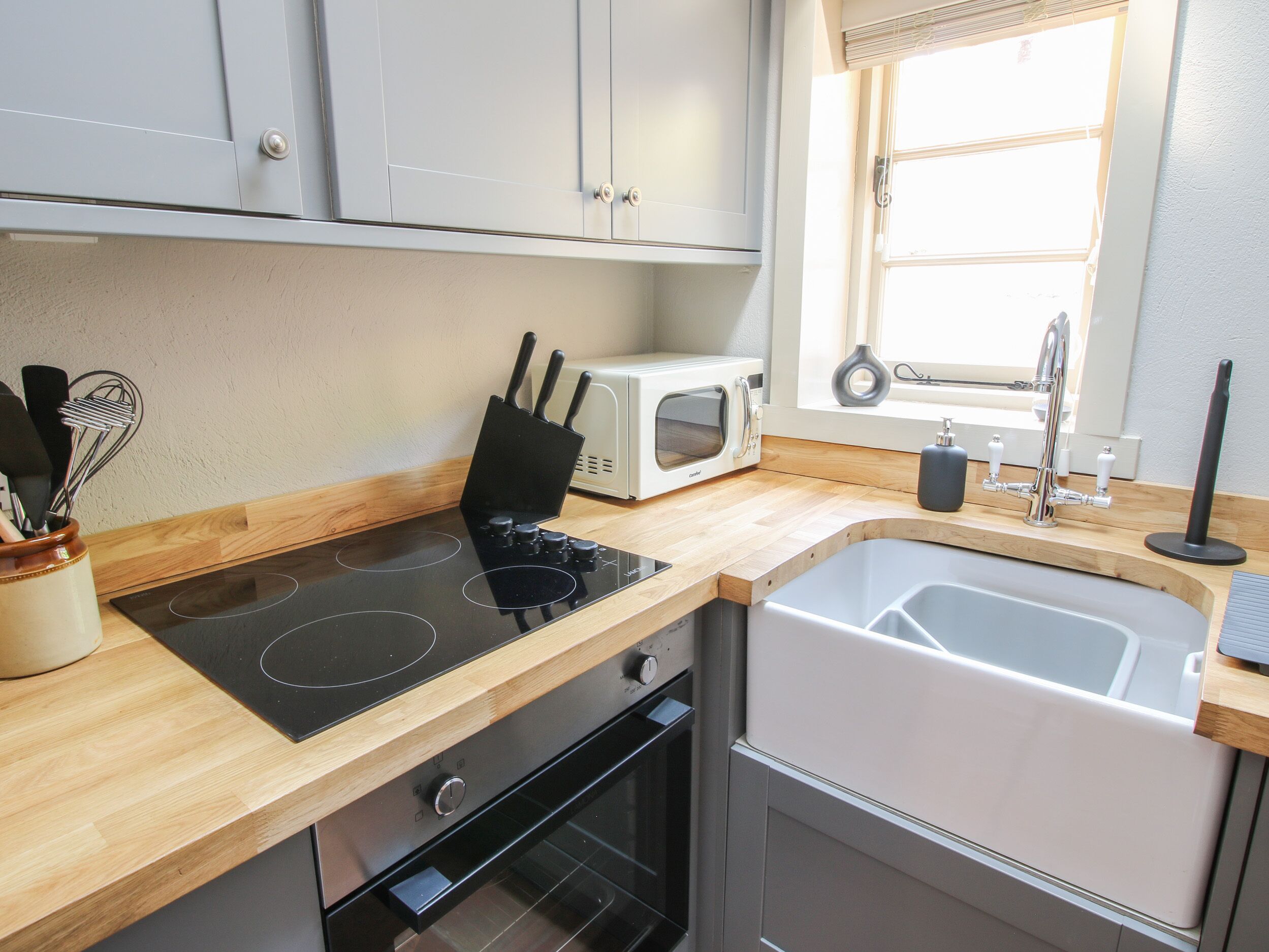A modern kitchen with a built-in stove, oven, microwave, and sink.