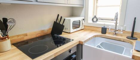 A modern kitchen with a built-in stove, oven, microwave, and sink.