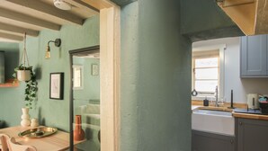 Een keuken met een houten tafel, stoelen en een hangplant.