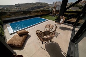 A rooftop terrace with a swimming pool, wicker furniture, and a view of the surrounding landscape. - Inviting 4-bed Villa Lia in Vathianos Kampos (Hersonissos)