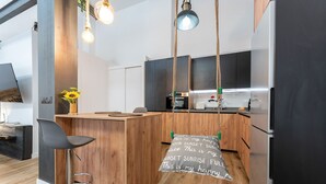 Een moderne keuken met houten keukenkastjes, een hanglamp en een keukenblok.