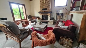 A cozy living room with a fireplace, comfortable seating, and a bookshelf.