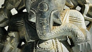 A detailed stone sculpture with multiple faces and intricate carvings. - Boutique Boat Stays Contemporary Barge (Bath)