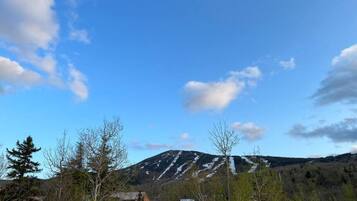 A mountain with a clear sky and sparse vegetation in the foreground.