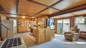 Ein Ferienhaus-Interieur mit einer Küche, einem Essbereich und einem Wohnbereich mit Fernsessel.