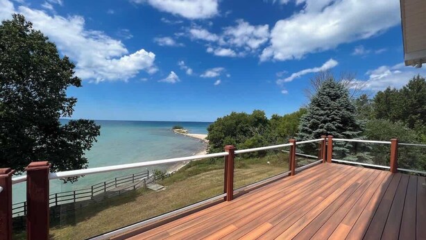 Eine Holzterrasse mit Blick auf Strand und Meer.