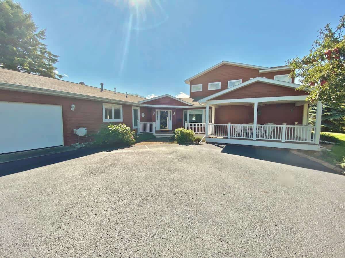 A two-story house with a covered porch and a garage.