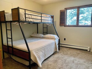 A bunk bed room with a window and a radiator.