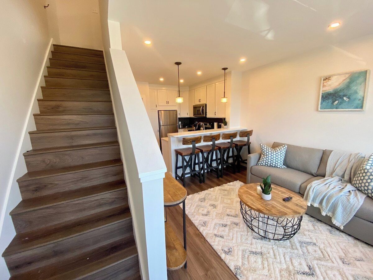 A modern kitchen with white cabinets, a central island, and pendant lighting.