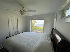Enjoy ocean views from the large bed positioned against a wall with a large window.