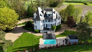 A large, two-story house with a swimming pool, surrounded by well-maintained lawns and trees. - Petit Manoir à 20 min de Disneyland Paris (Montceaux-lès-Meaux)