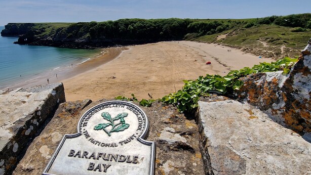 Vista sulla costa con un cartello che indica 'Barafundle Bay'.