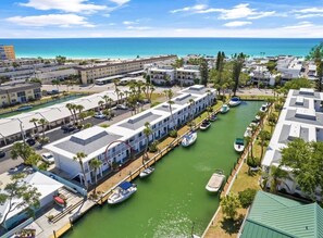A marina with boats docked, a water canal, and buildings with a uniform architectural style.