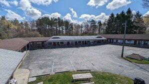 A motel with a large parking lot, multiple rooms, and a covered outdoor area. - Nova Motel (Ludington)
