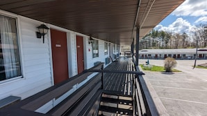 A motel with a covered porch, numbered rooms, and a parking lot. - Nova Motel (Ludington)
