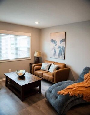 Relax in this stylish living room with a leather sofa, armchair, and floor lamp.