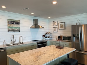 Enjoy cooking in this kitchen with a large island, gas range, and stainless steel appliances.