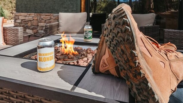 An outdoor seating area with a fire pit, a can of beer, and a pair of shoes.