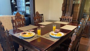 Una mesa de comedor con dos platos de comida y un vaso de jugo de naranja.