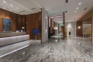 A hotel lobby with a reception desk, marble flooring, and a modern interior design. - Golden Splendid Hotel (Zhanjiang)