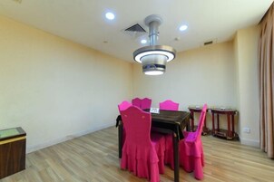 Un comedor con una mesa, sillas, un ventilador de techo y una mesita auxiliar.