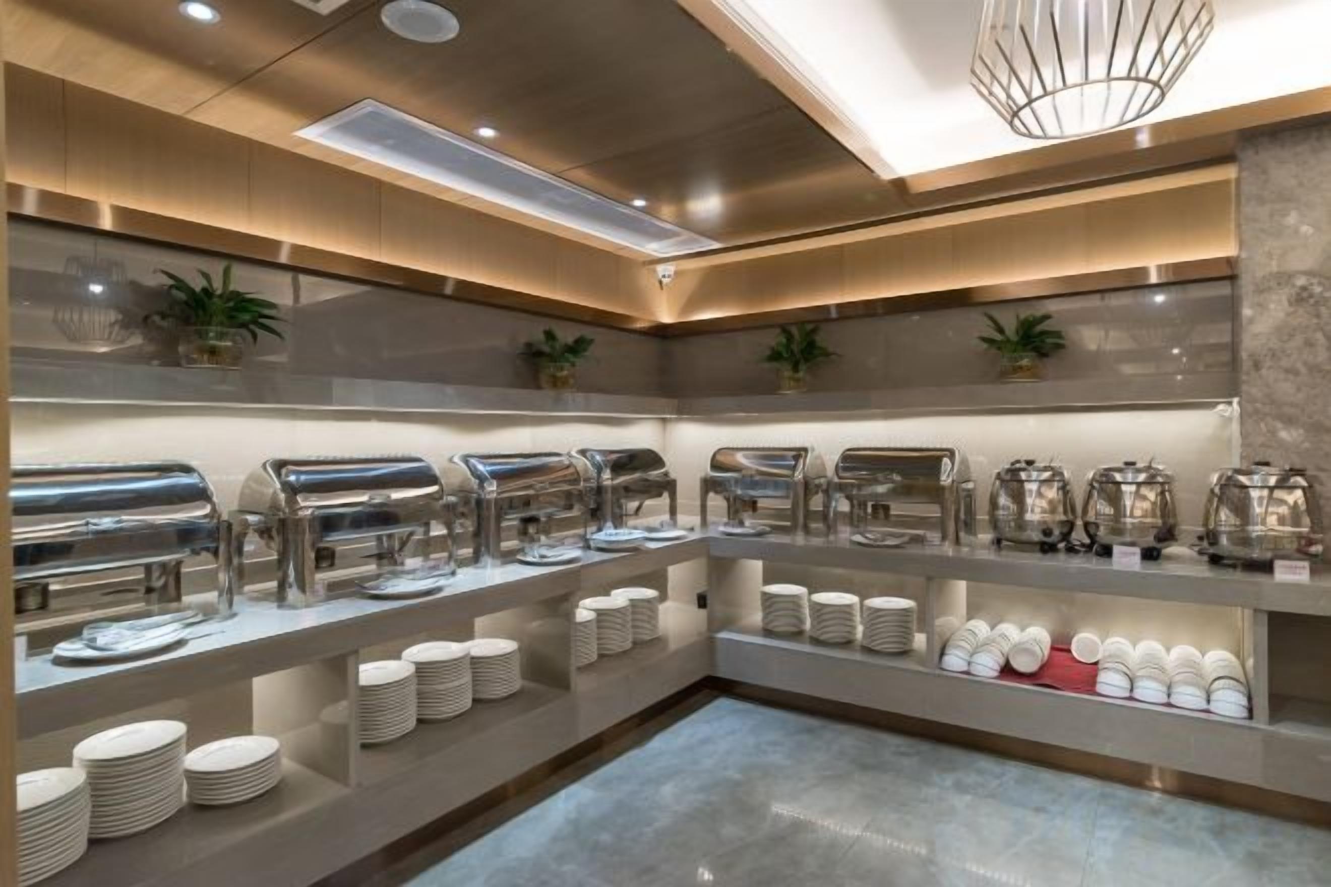 A buffet setup with multiple self-service stations, including hot and cold food options, and a variety of serving dishes.
