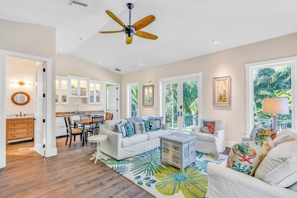 A spacious living room with a white sofa, a coffee table, and a ceiling fan. - P04 - Beach Front Estate with Pool and 6 bedrooms (Marathon)