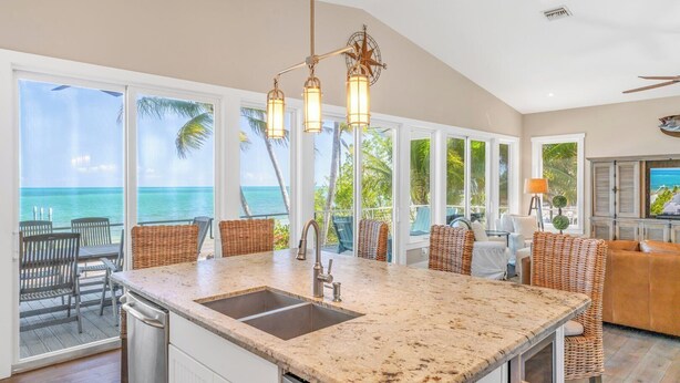 A kitchen with a large island, a sink, and a view of the ocean. - P04 - Beach Front Estate with Pool and 6 bedrooms (Marathon)
