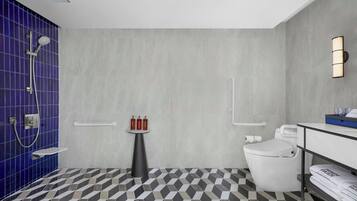 A modern bathroom with a shower, toilet, and sink.