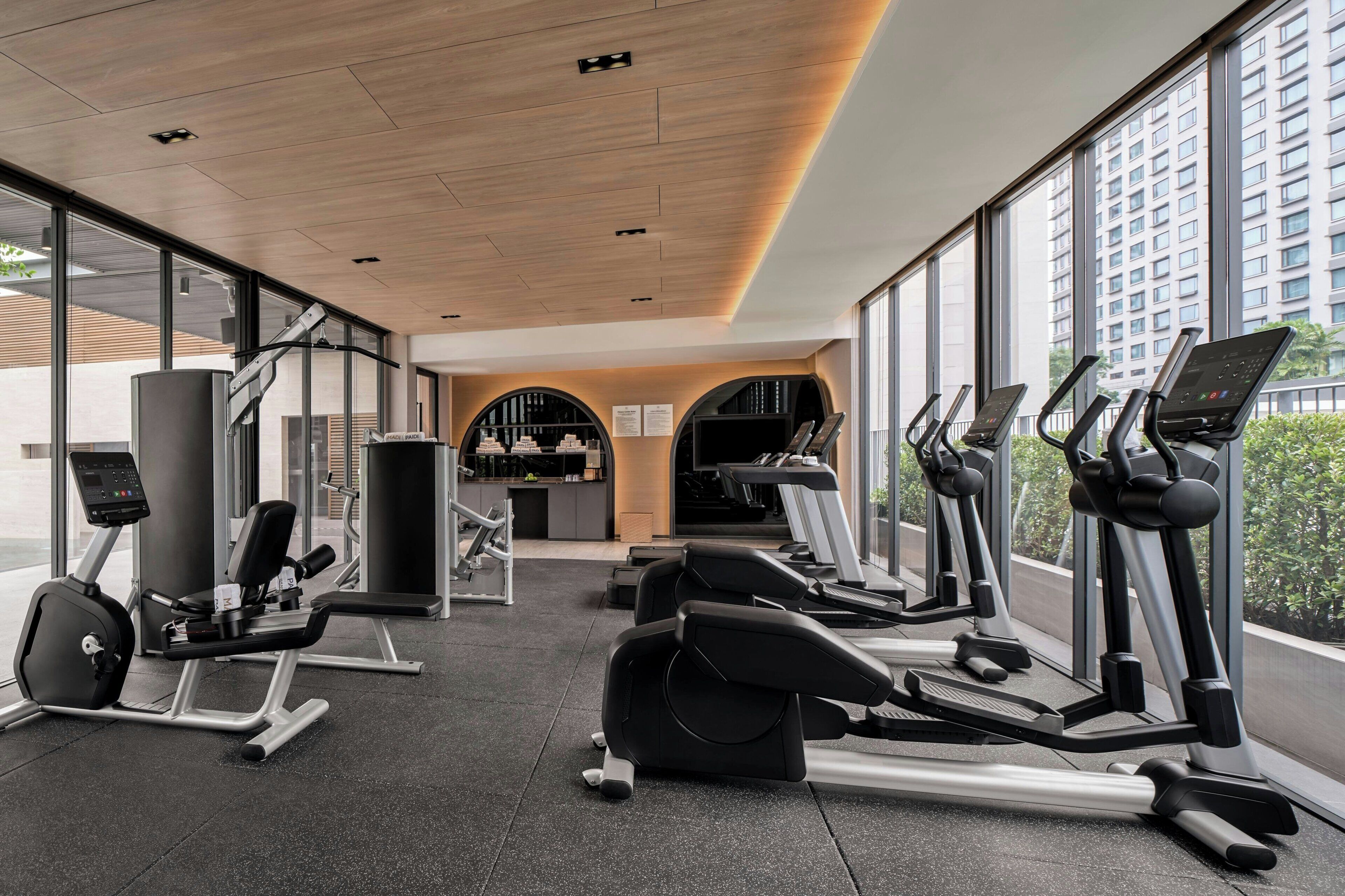 Een sportschool met loopbanden, elliptische trainers en gewichten.