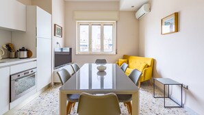 A compact kitchen with a dining area, a yellow armchair, and a small table. - La Dimora dell'Avvocato (Naples)