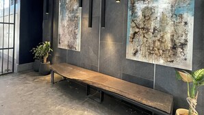 Un moderno vestíbulo con un banco, pinturas abstractas y plantas en macetas.