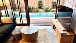 A modern living room with a sofa, a round coffee table, and a TV stand.