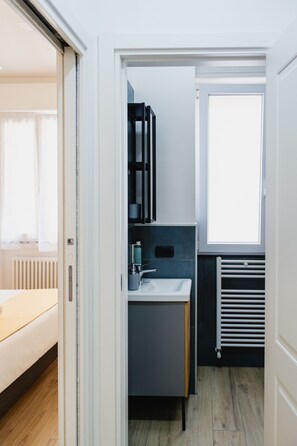 Une salle de bain moderne avec un lavabo, un miroir et un radiateur.