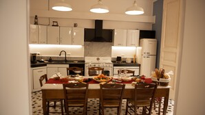 A kitchen with white cabinets, a stove, and a dining table set for four. - B&B U'Panare, in Taranto's historic center a structure reminiscent of home (Taranto)