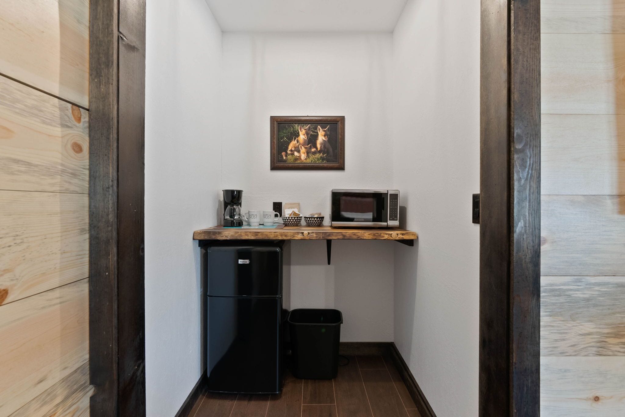 A compact kitchenette with a microwave, coffee maker, and small refrigerator.