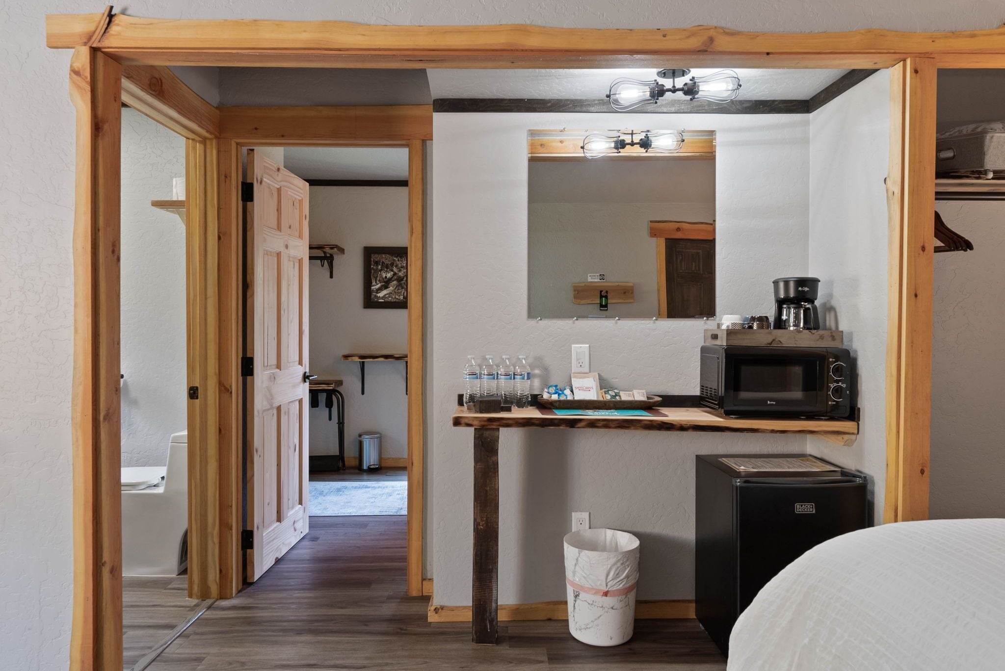 Una cocina compacta con encimera de madera, microondas, tostadora y un lavamanos.