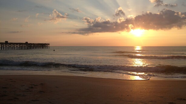 A beach with a pier extending into the ocean during sunset. - Tropical Hideaway in Downtown Flagler Beach (Flagler Beach)