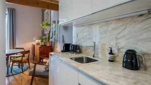 Una cucina moderna con un piano di lavoro in marmo, un lavello, una macchina da caffè e un tostapane.