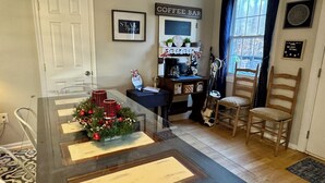 A dining area with a glass table, red and white striped candles, and a Christmas tree decoration. - Country Escape Next DOOR Rental - Sleeps 6 - Stay upstairs in the trees  (Chesapeake)