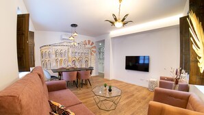 A modern living room with a sofa, a glass coffee table, and a dining area with chairs and a table. - ALFICEN CERVANTES 5 COLLECTION (Toledo)