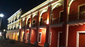A multi-story building with balconies and a red facade. - Hotel Posada Doña Lala (Tlacotalpan)
