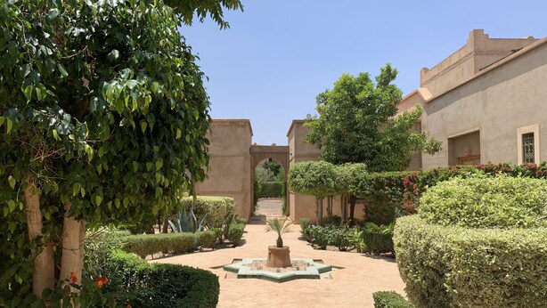 A courtyard with a central fountain, surrounded by neatly trimmed hedges and trees. - Rita House le Petit Paradis sur Terre (Marrakech)