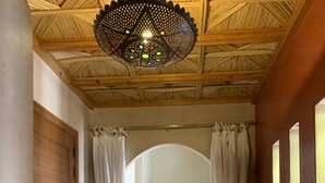 A hallway with a wooden ceiling, white curtains, a staircase, and a table with decorative items. - Rita House le Petit Paradis sur Terre (Marrakech)