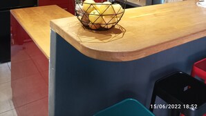 A modern kitchen with red cabinets, a black refrigerator, a microwave, and a wooden countertop. - Maison de Vacances, Proche de la Plage! (Fréjus)