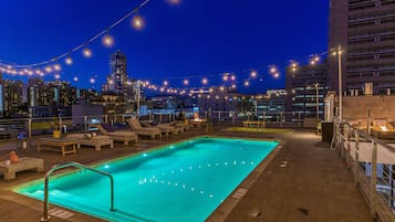Relax by the rooftop pool surrounded by lounge chairs and take in the city skyline views.