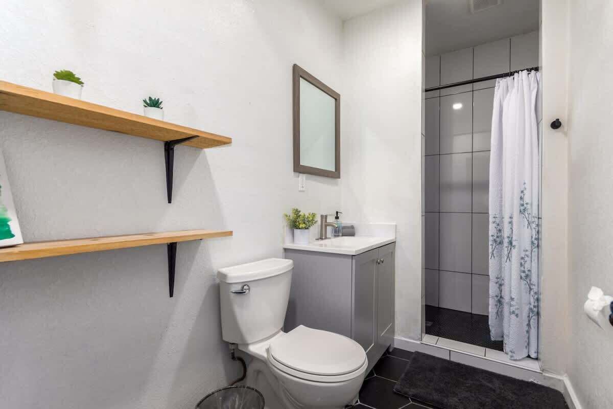 Stylish and modern bathroom featuring open shelving, sleek fixtures, and a walk-in shower for ultimate convenience.